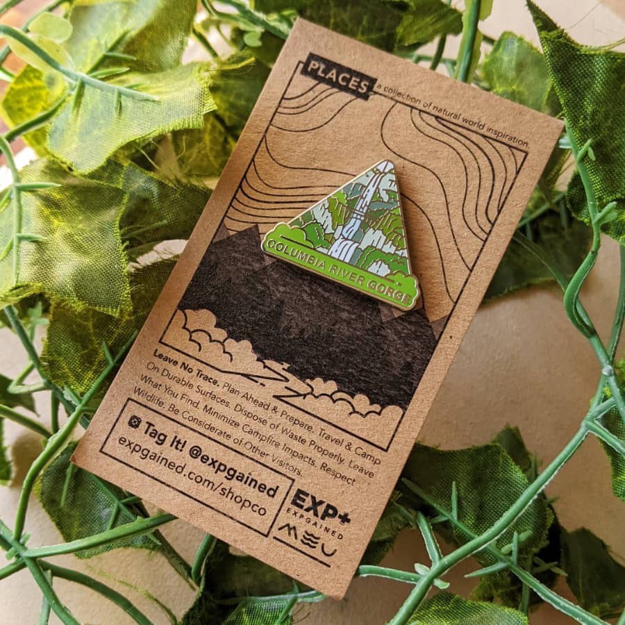 Triangle Columbia River Gorge enamel pin featuring a view from the beehive hike on a brown business card size backing card featuring the Places colleciton design.