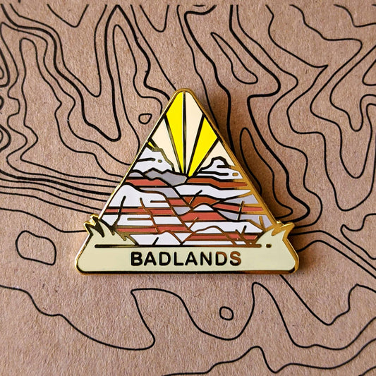 Triangle Badlands national park enamel pin featuring a view of sharp pinnacles found throughout the park.