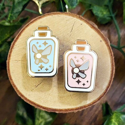 Glow in the dark blue and pink fairy in a rectangular bottle enamel pins.