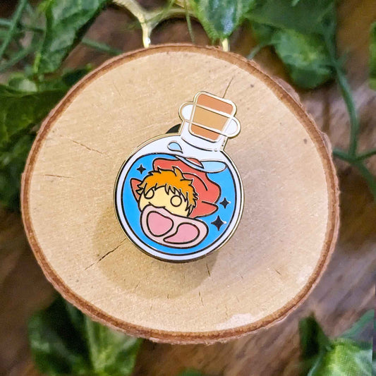Orange haired fish girl with a piece of ham swimming in the water in a potion bottle enamel pin designed by EXP Gained