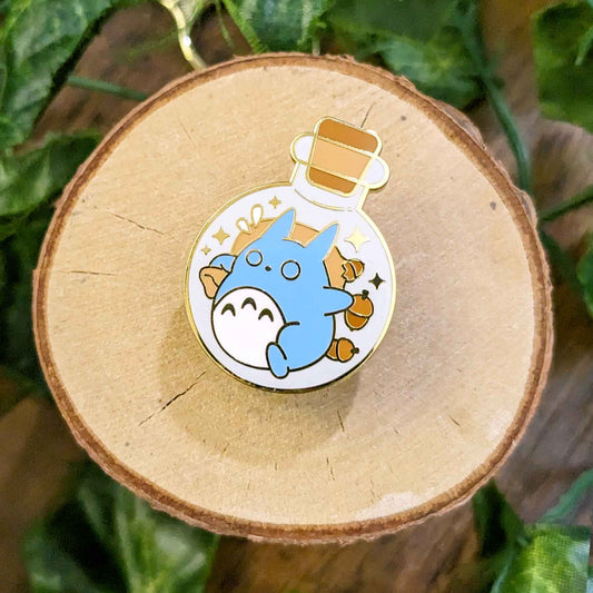 Running shy collector blue rabbit with a ripped bag of acorns falling out in a potion bottle enamel pin designed by EXP Gained