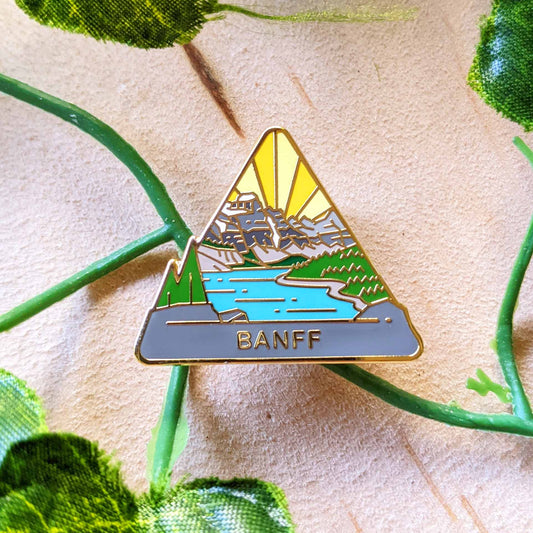 Triangle Banff national park enamel pin featuring a view of Moraine Lake.
