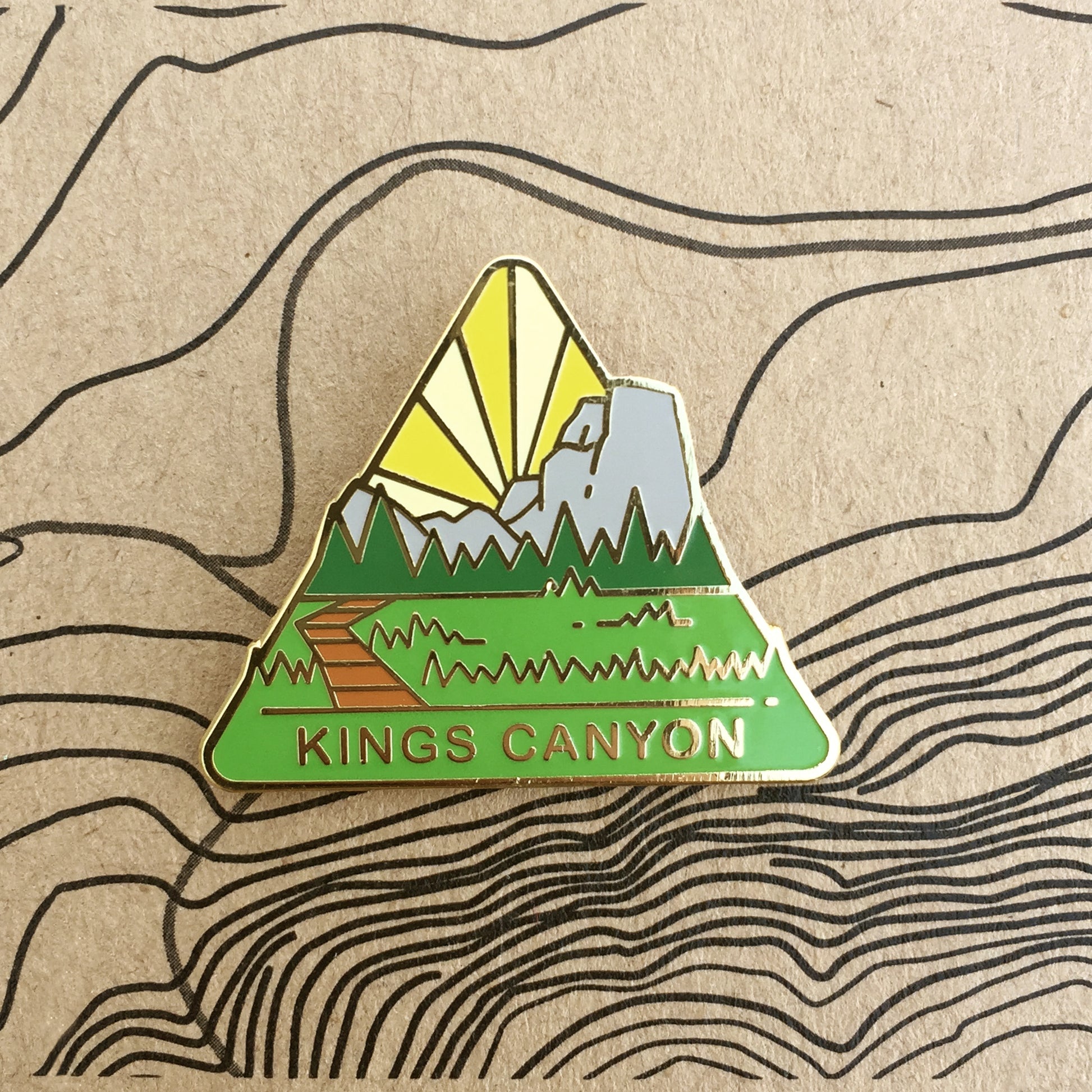 Triangle Kings Canyon national park enamel pin featuring a view of meadows between mountains.